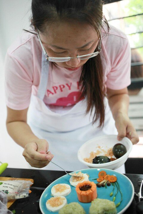 Chị Hạnh đang trang trí món ăn.
